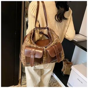 Detail of tweed multi-pocket shoulder bag with brown leather accents and straps