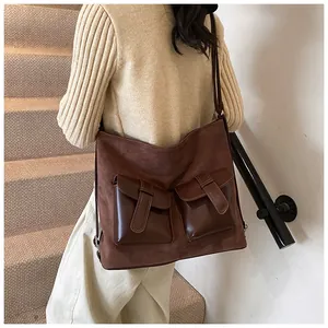 Macro detail of dark brown vintage motorcycle bag with utility pockets and matte finish