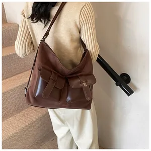 Detailed back view of a vintage brown suede crossbody bag with double front buckle pockets