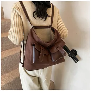 Detail view of dark brown multi-pocket convertible backpack on model during daily commute