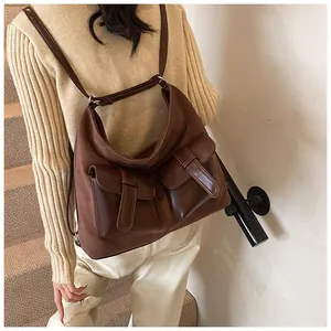 Detailed view of dark brown oversized multi-pocket crossbody bag in retro suede material