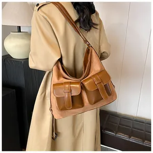 Detail of vintage suede shoulder bag with multi-pocket design on khaki trench coat