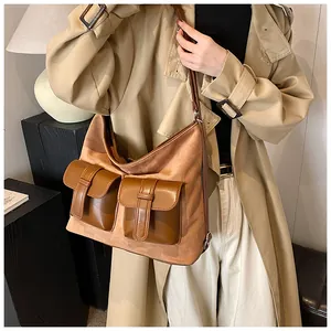 Detail view of large vintage brown hobo bag with buckled pockets and mixed leather texture