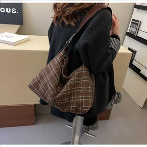 Détail d'un grand sac cabas à carreaux marron avec bandoulière nouée au style rétro