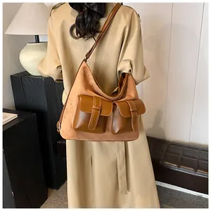 Detail of caramel brown multi-pocket hobo bag in suede and faux leather stitching