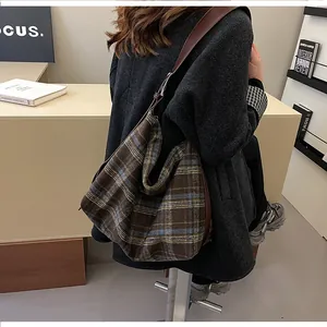 Détail du sac hobo à carreaux avec une bandoulière en cuir marron foncé