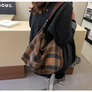 Détail du sac hobo à carreaux avec bandoulière réglable en cuir marron et fermeture éclair