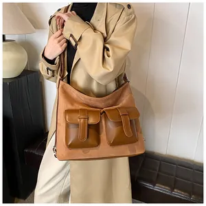 Detail of camel suede patchwork bag with multi-pocket design and retro styling