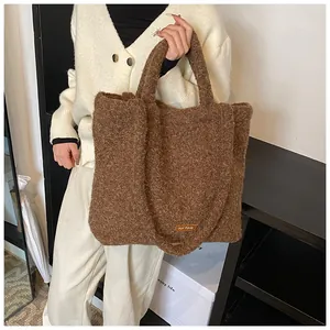 Dettaglio della borsa tote in peluche marrone con etichetta e texture morbida