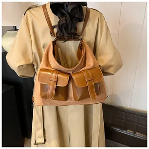 Detail of camel suede backpack featuring brown leather pockets and vintage metal buckles