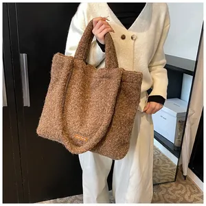 Dettaglio della borsa tote marrone morbida con texture pelosa e etichetta arancio