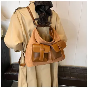 Detail of vintage suede backpack with double brown pockets shown on a beige trench coat