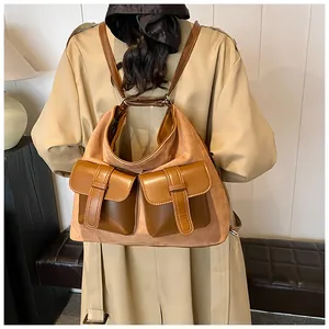 Detail of vintage brown suede backpack with buckle pockets worn on model's back