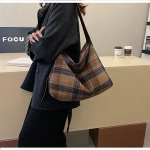 Détail du grand sac hobo à carreaux avec large bandoulière en cuir d'automne