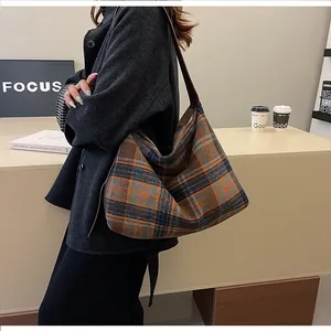 Vue détaillée du grand sac cabas à carreaux avec bandoulière à nœud dans un café chic