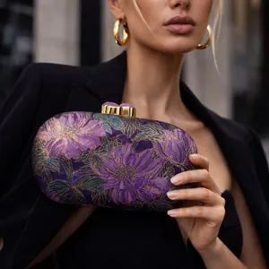 Elegant purple hard shell evening clutch bag with intricate 3D floral embroidery and gold clasp