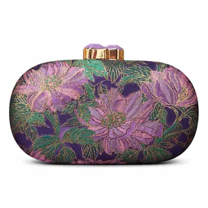 Detail of floral brocade evening clutch with purple fabric and gold gemstone clasp