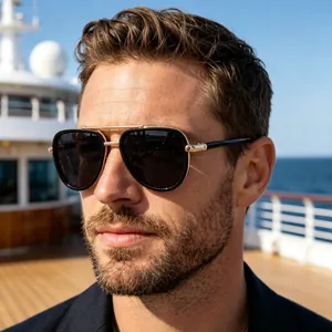 Detail of pilot sunglasses with gold metallic temples worn by a man on a yacht