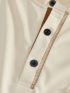 Makro-Detail des Herren-Polo-Ausschnitts mit braunem Kontrastbesatz und schwarzen Knöpfen