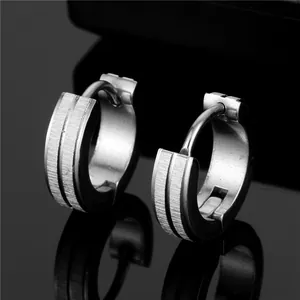 Macro detail of silver brushed titanium steel hoop earrings with parallel groove design