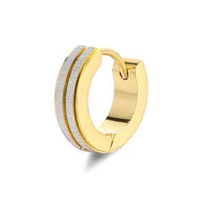 Detail of two-tone gold and silver huggie earring with matte brushed and polished finish
