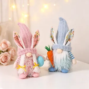A pair of decorative Easter bunny gnomes holding a carrot and a blue polka dot egg