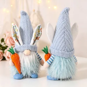 Close-up front and back view of two blue plush Easter gnomes holding orange carrots
