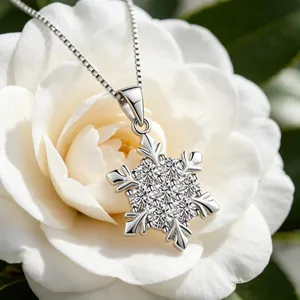 Macro del ciondolo a fiocco di neve in argento S925 con zirconi su camelia bianca