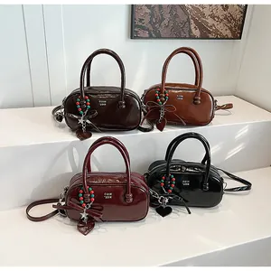 Detail of Boston bags in four colors with glossy finish and decorative heart charms