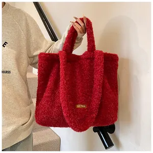 Dettaglio della borsa tote rossa in peluche con texture soffice e patch logo in pelle