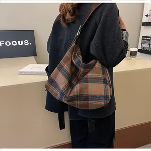 Détail du sac hobo à carreaux avec bandoulière réglable en cuir marron et motif écossais