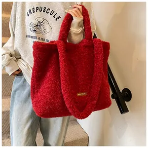 Dettaglio della borsa tote in peluche rosso con pelliccia sintetica e etichetta in cuoio