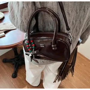 Detail of chocolate brown glossy faux leather handbag with star and bow charms