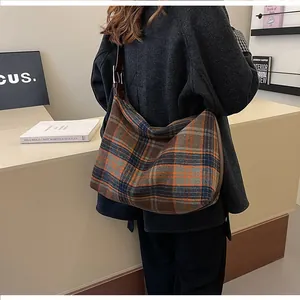 Détail d'un grand sac hobo à carreaux rétro avec tissu épais et large bandoulière