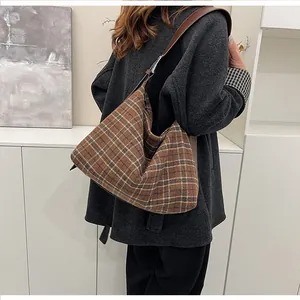 Détail du sac cabas hobo à carreaux marron avec bandoulière en cuir sur modèle