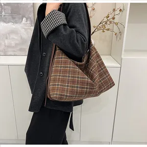 Vue détaillée du grand sac cabas à carreaux marron sur modèle montrant le drapé souple