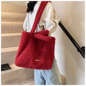 Dettaglio della borsa tote in peluche rosso con consistenza morbida ed etichetta
