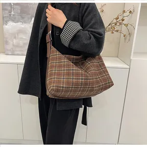 Détail du sac hobo à carreaux montrant sa grande capacité et sa bandoulière en cuir