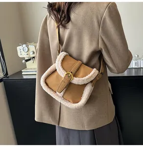 Gros plan d'un sac besace marron en imitation mouton avec boucle dorée sur un mannequin