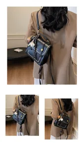 Detail of vintage black briefcase bag featuring gold rivets and baseball charm