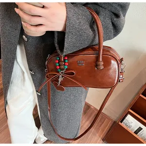 Brown leather Boston bag with holiday charms and brand logo in a winter street style
