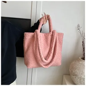 Dettaglio della borsa tote rosa peluche con trama in lana di agnello e doppi manici