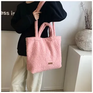Dettaglio della borsa tote rosa in morbido peluche con etichetta in pelle marrone