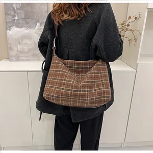 Vue arrière d'un grand sac hobo à carreaux marron en laine avec bandoulière en cuir