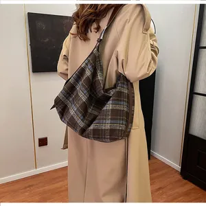 Sac fourre-tout à carreaux porté avec un trench beige pour un look d'automne classique