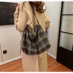 Détail d'un grand sac hobo en tissu tissé avec motif à carreaux marron et bleu