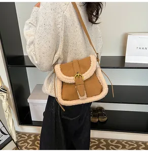 Détail de sac bandoulière en suède marron avec garniture en fausse fourrure et boucle