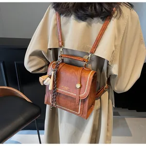 Detail shot of brown retro faux leather mini bag featuring golden hardware and sporty charms