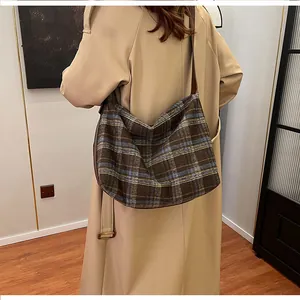 Détail du sac hobo à carreaux vintage avec grande capacité et ruban sur un modèle