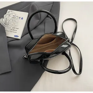 Top view of patent leather handbag interior showing brown fabric lining and pockets